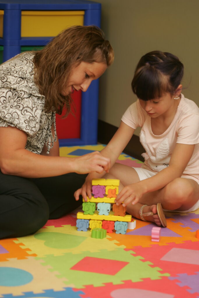 Board Certified Behavior Analyst practices behavioral therapy with young girl. ABA Therapy, autism services in Spokane